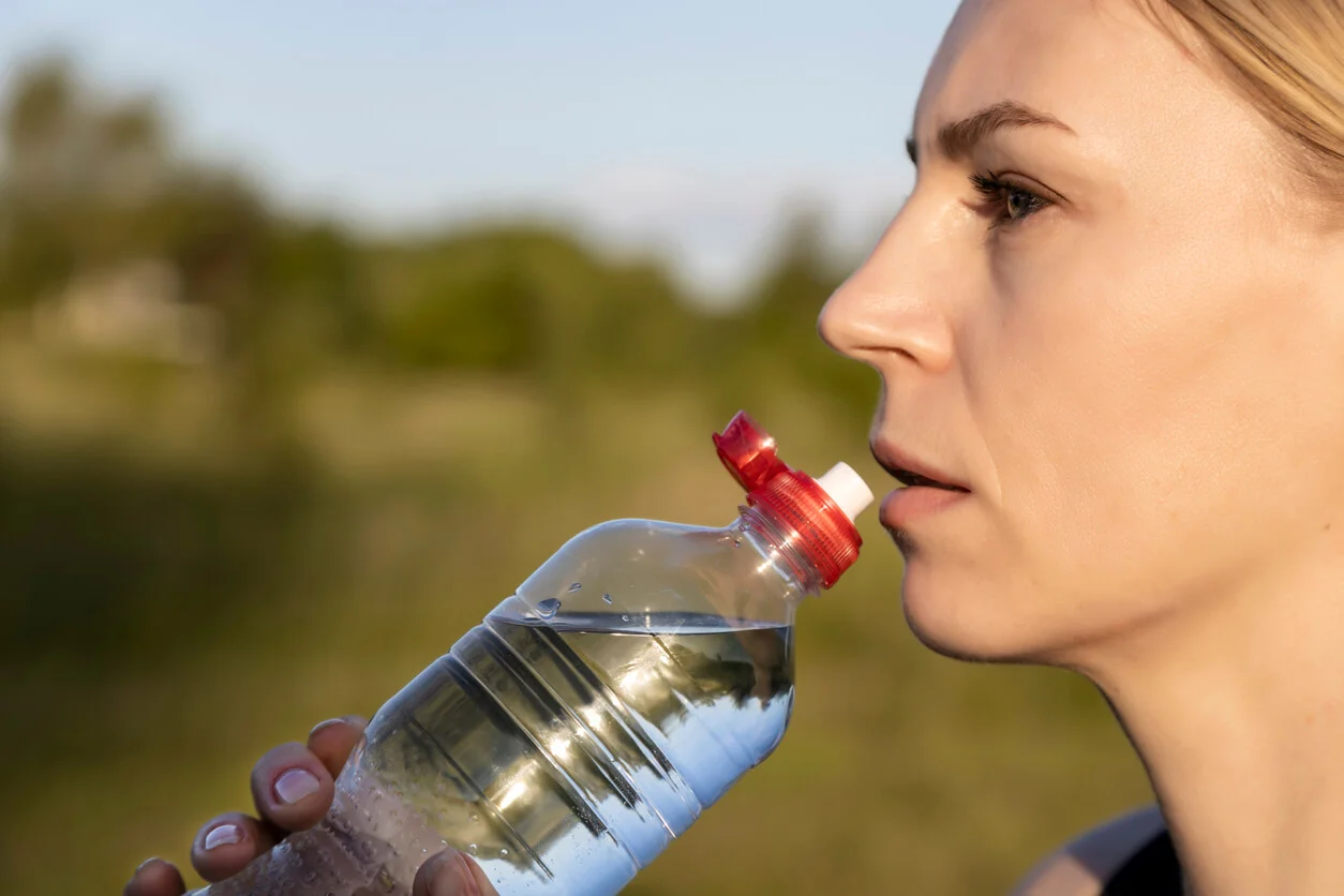 mujer-bebe-agua-botella-plastico